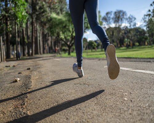 Person jogging in the park maintaining active lifestyle
